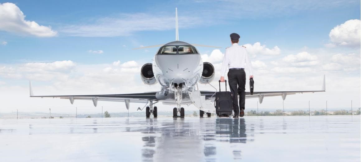 Pilot walking towards a private jet on the tarmac
