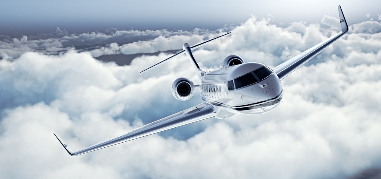 Modern private business jet flying over the clouds